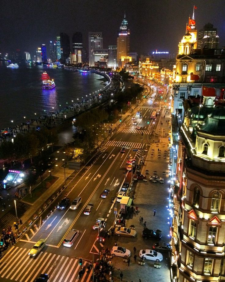 an aerial view of a city at night with traffic on the street and buildings in the background