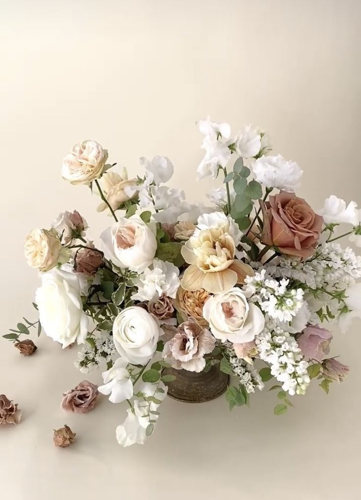 a vase filled with lots of white and pink flowers