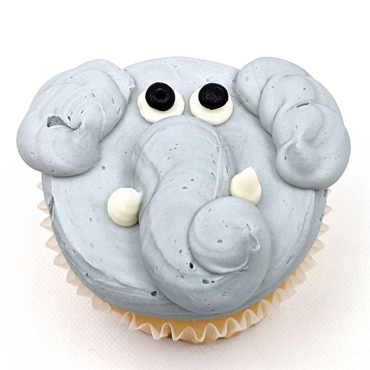 an elephant cupcake with white frosting and black eyes