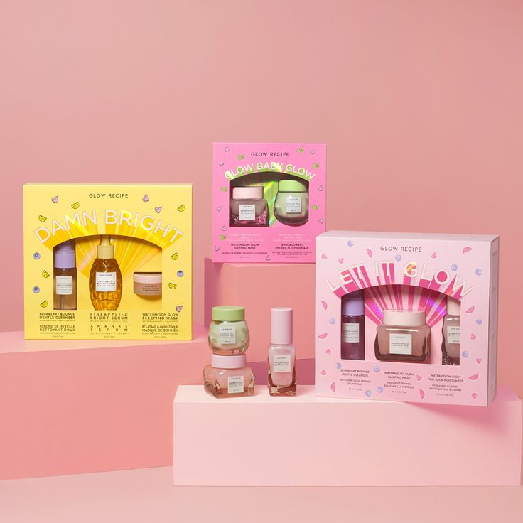 an assortment of skin care products displayed on a pink and yellow background with two boxes