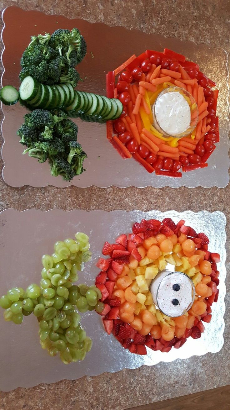 two trays with fruits and vegetables on them