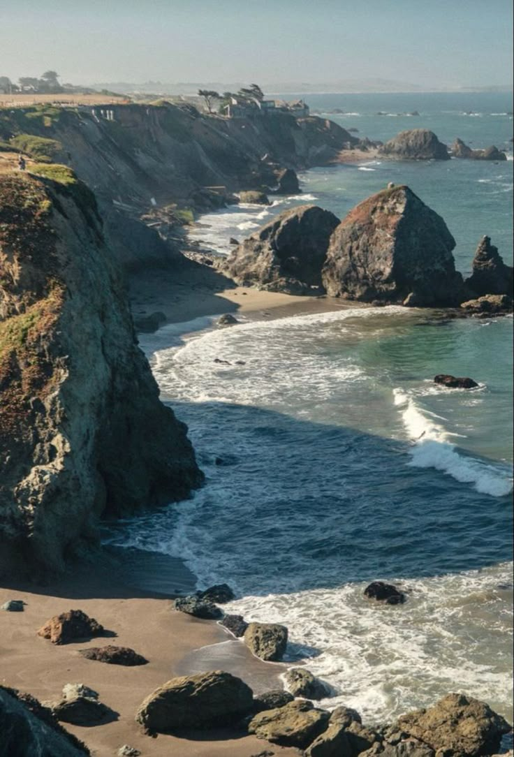 an ocean view with waves crashing on the shore