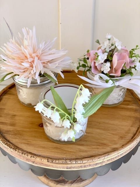 three vases with flowers are sitting on a table