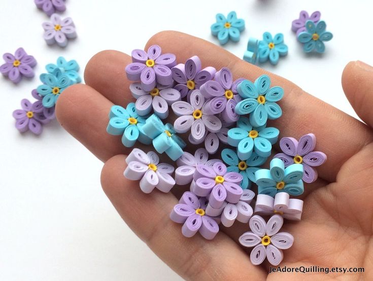 small purple and blue flowers are being held in someone's hand