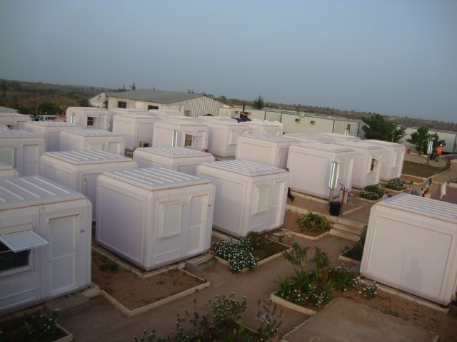 many white portable homes are lined up in a lot