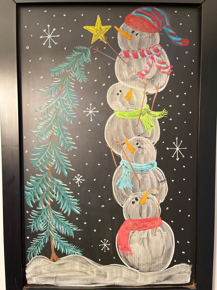 a chalkboard drawing of three snowmen and a christmas tree with stars on it