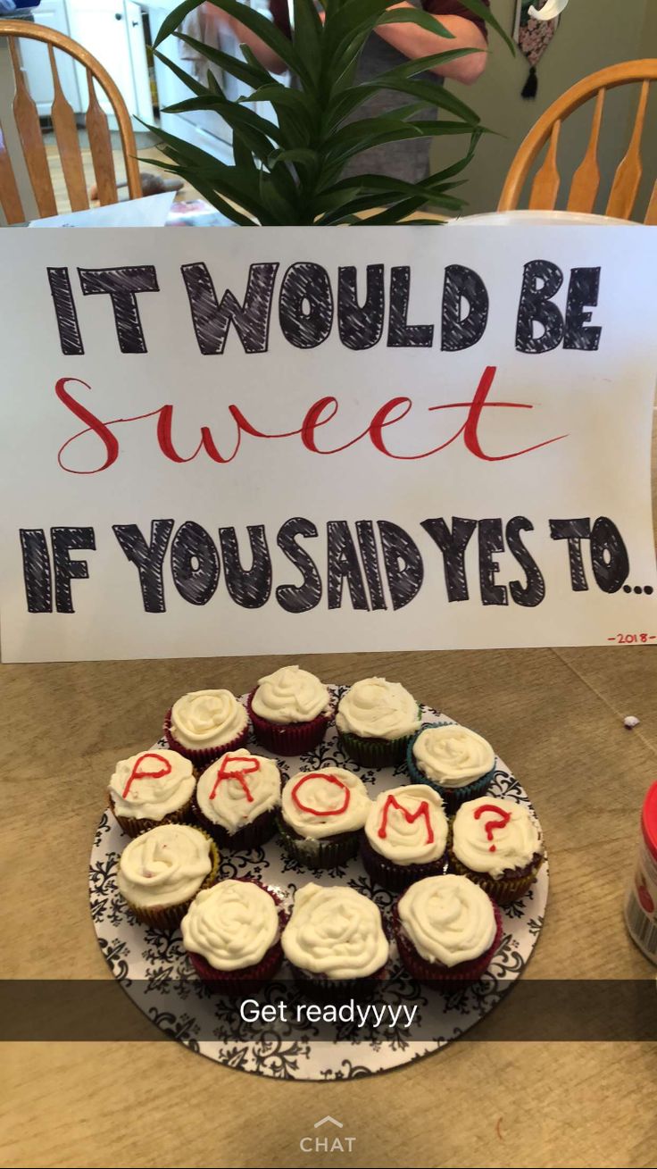 cupcakes on a plate with a sign that says it would be sweet if you said yes to