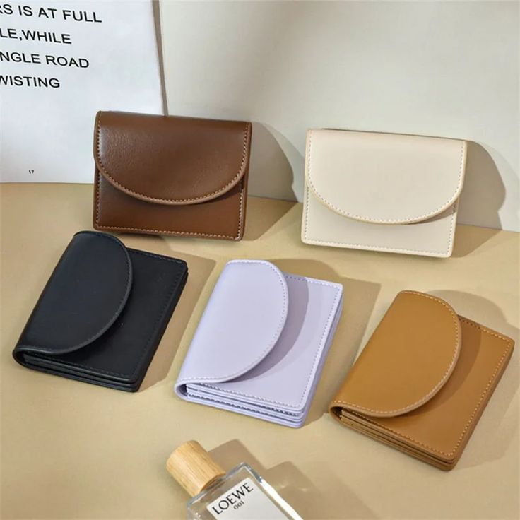 four different types of wallets sitting on top of a table next to each other