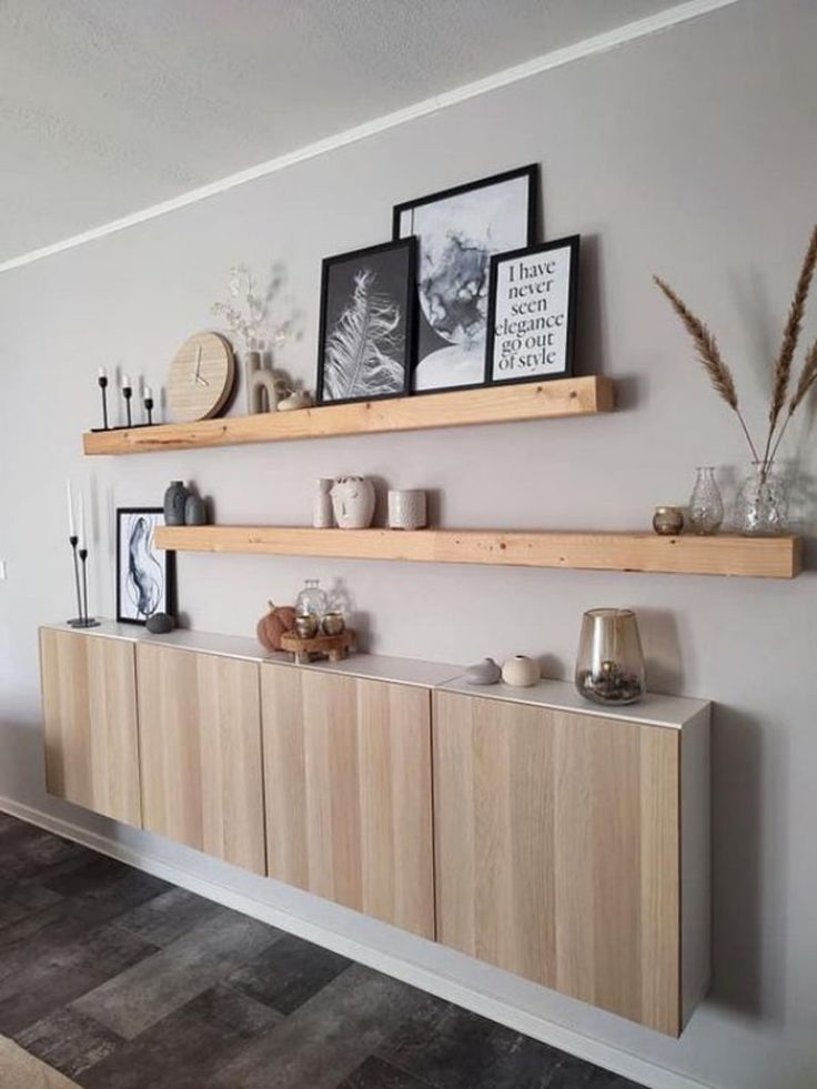 two wooden shelves on the wall with pictures above them