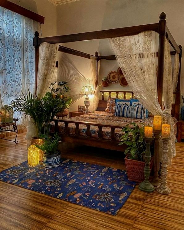 a canopy bed sitting in the middle of a living room next to a wooden floor