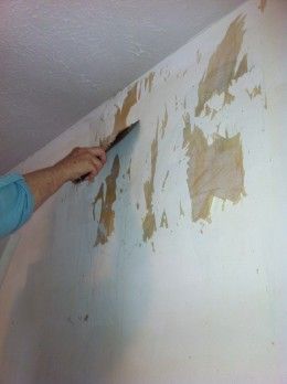 a man is painting the wall with brown paint