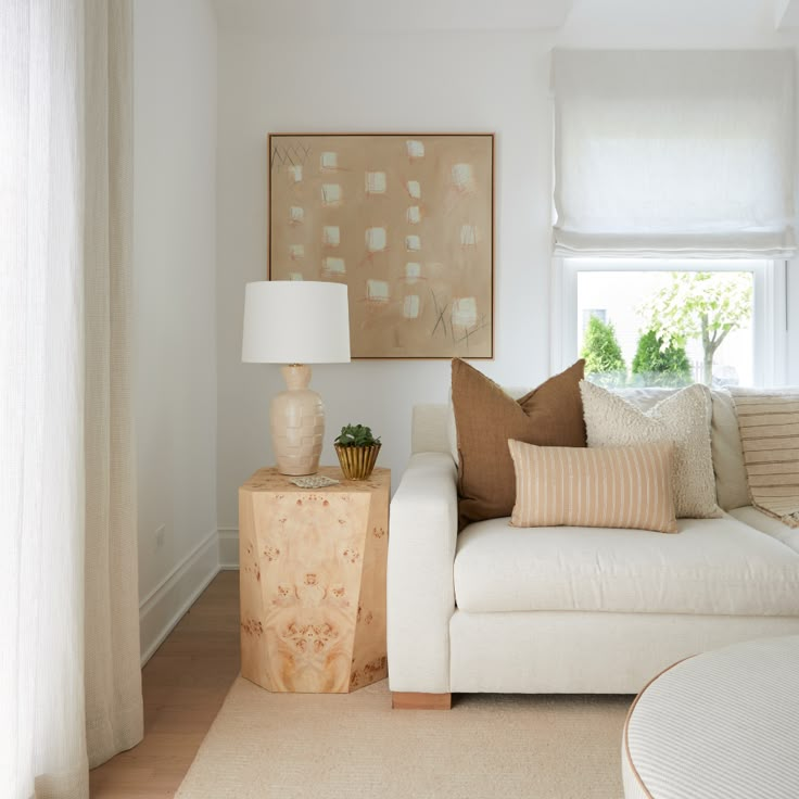 a living room with a white couch and two lamps on the side tables in front of it