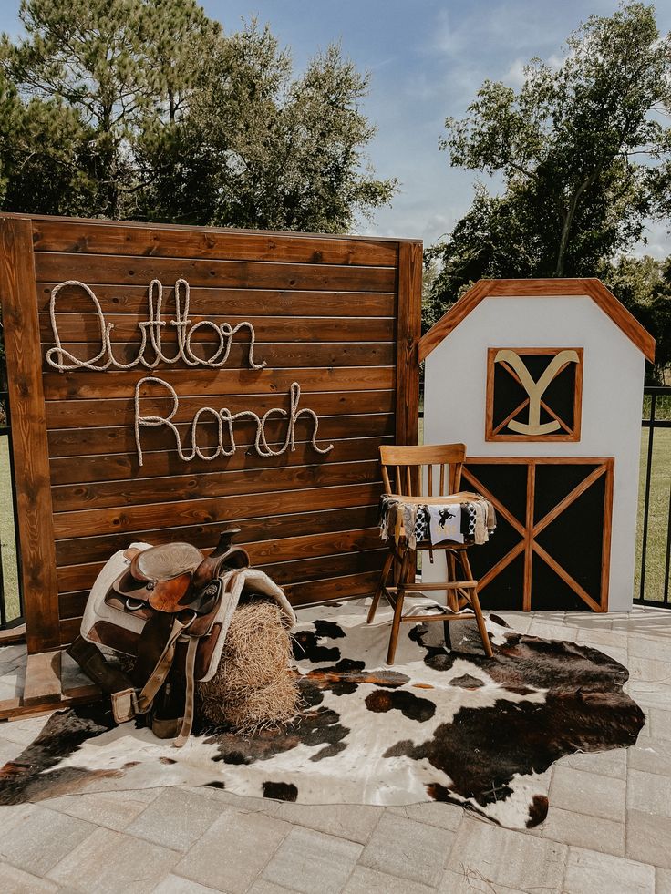 a wooden sign that says butter ranch next to a chair and cow skin rug on the ground