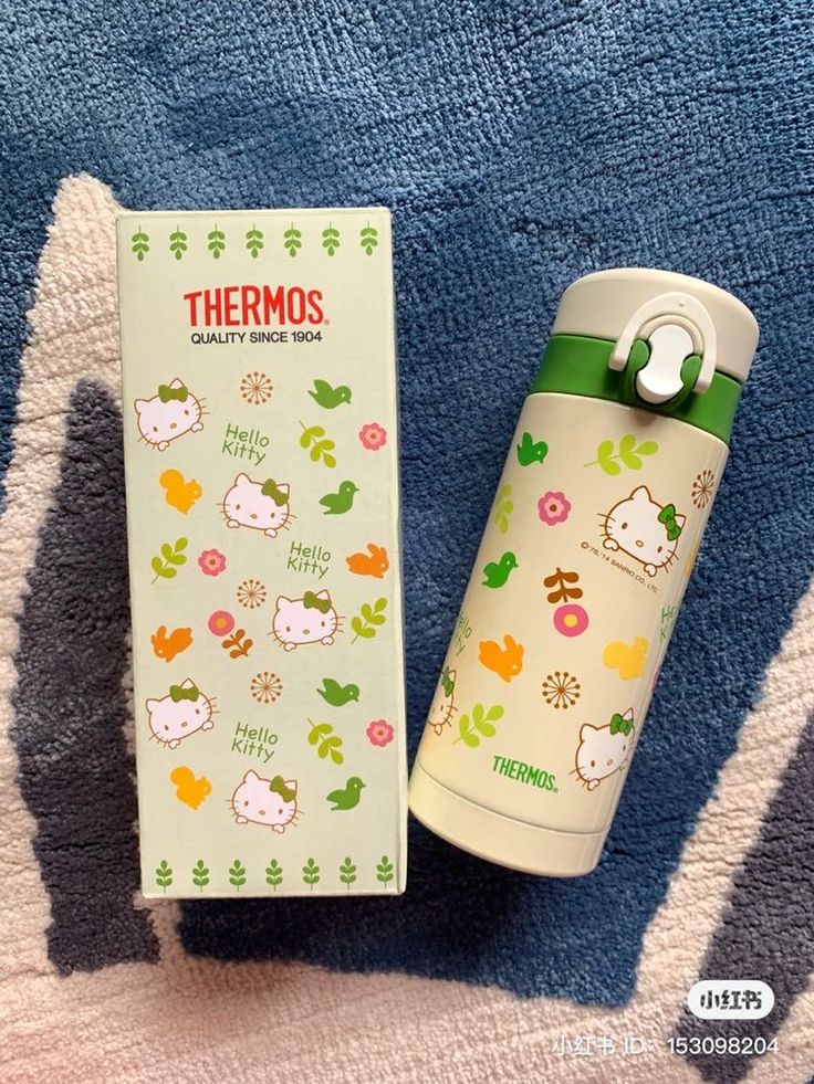 thermos insulated water bottle with hello kitty stickers on it next to its packaging