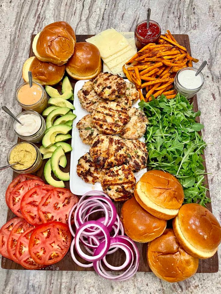 an assortment of food including burgers, french fries and tomatoes