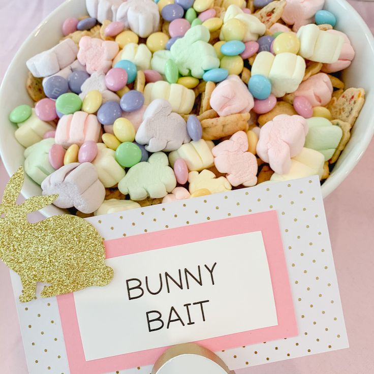 a bowl filled with lots of candy and marshmallows next to a sign that says bunny bat