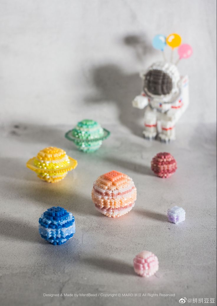 small beads are arranged on a table next to a toy spaceman and other objects