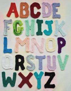 crocheted letters and numbers are displayed on a white surface