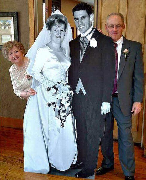 a bride and groom posing for a photo with their parents