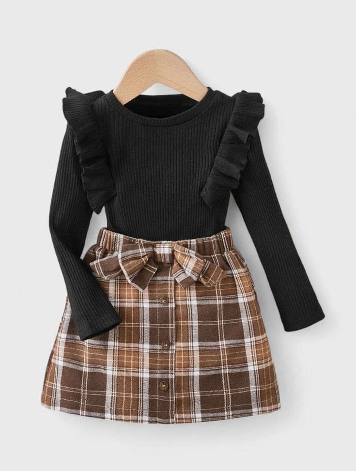 Get your little one ready for the holidays with our Ribbed Knit Ruffle Trim Top & Belted Plaid Flannel Skirt set. Perfect for Christmas, this festive outfit features a cozy ribbed knit top with delicate ruffle trim, paired with a classic plaid flannel skirt complete with a stylish belt. Your child will look adorable and feel comfortable, making this ensemble ideal for holiday gatherings and festive celebrations. Costum Elegant, Plaid Skirt Set, Long Sleeve Ruffle Top, Flannel Skirt, Bow Skirt, Black Children, Plaid Bow