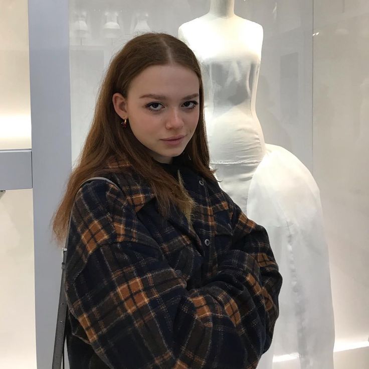 a woman standing in front of a mannequin