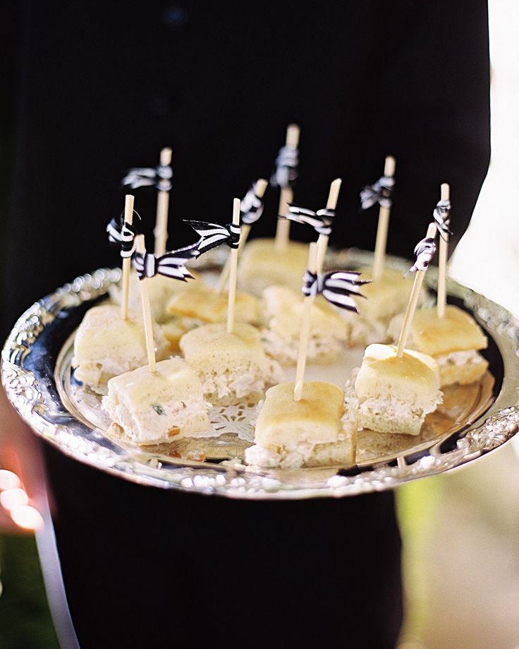 a silver plate topped with food covered in marshmallows and toothpicks