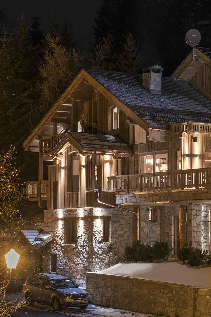 a large house lit up at night with lights on the front and side of it