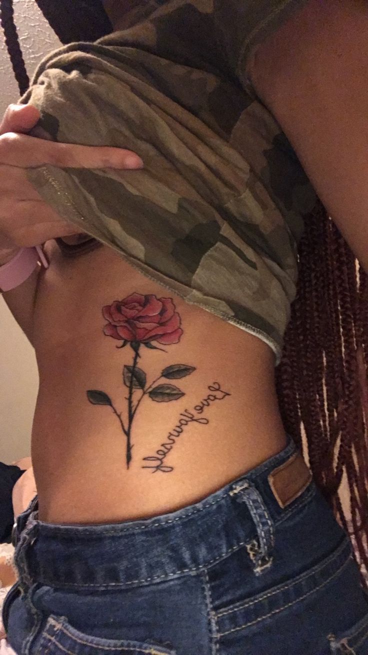 a woman's stomach with a rose tattoo on her side and the words, i love you