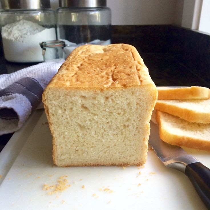 a loaf of bread sitting on top of a white cutting board next to a knife