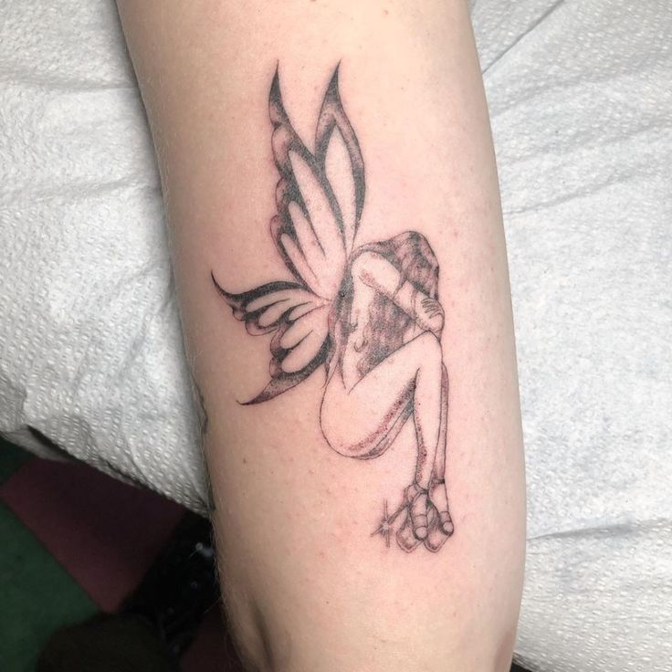 a tattoo on the arm of a woman with a flower in her hand and a small fairy