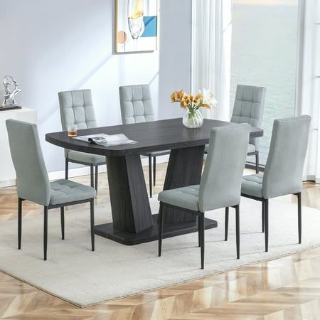 a dining room table with grey chairs around it