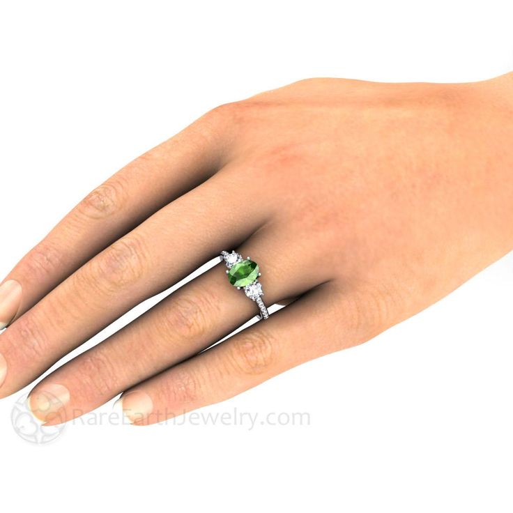 An absolutely stunning 3 stone Tsavorite Garnet and Diamond ring in your choice of 14K or 18K White, Yellow or Rose Gold. The center stone is a lovely oval cut .95ct brilliant natural Tsavorite Garnet. It has a two gorgeous .33ct diamonds, one on each side, and diamonds cascading down the band, .82ctw. Gorgeous! This ring would make a beautiful engagement ring. The matching wedding band is also available. Ask for a quote on the set. Official Website: www.RareEarthJewelry.com SCHEDULE This ring i Green Diamond Birthstone Ring Round Cut, Green Diamond Birthstone Ring With Accent Stones, Green Emerald Three Stone Wedding Ring, Fine Jewelry Emerald Three Stone Promise Ring, Fine Jewelry Three Stone Emerald Promise Ring, Fine Jewelry Three Stone Emerald Ring For Promise, Anniversary Tsavorite Birthstone Ring With Gemstone, Green Diamond Ring With Three Stones, Green Birthstone Ring With Brilliant Cut