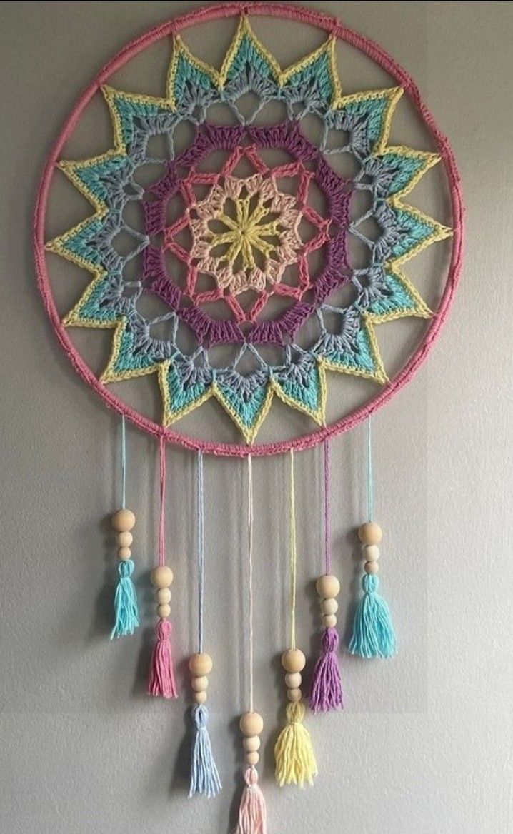 a crocheted dream catcher hanging on the wall