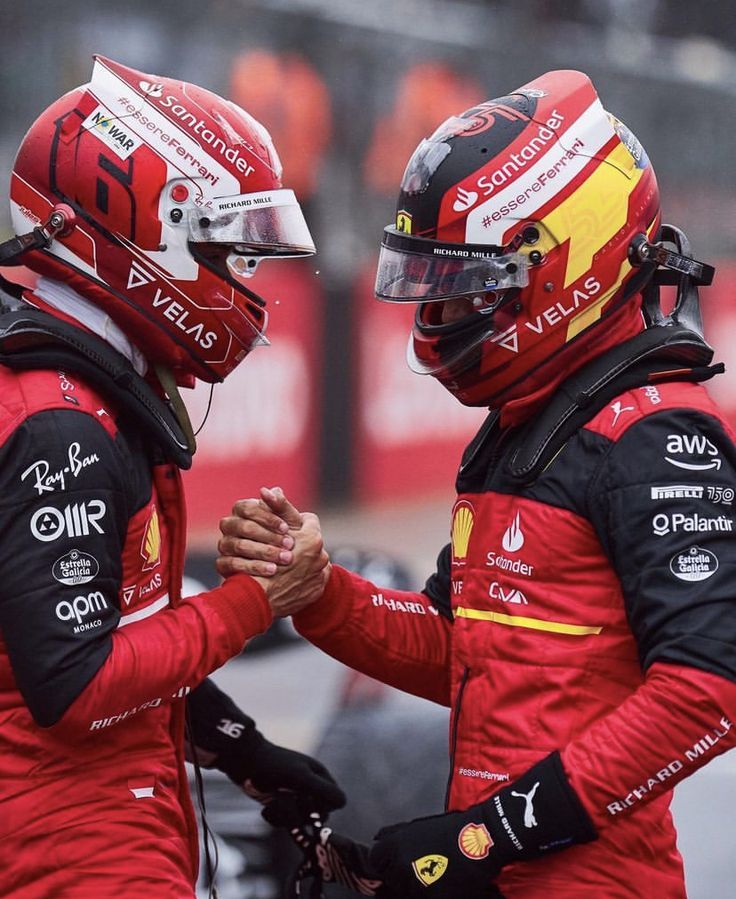 two men in red racing uniforms shaking hands