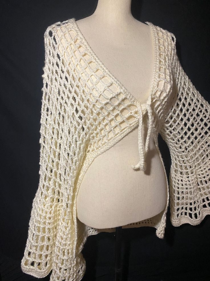 a white crocheted shawl on top of a mannequin's head