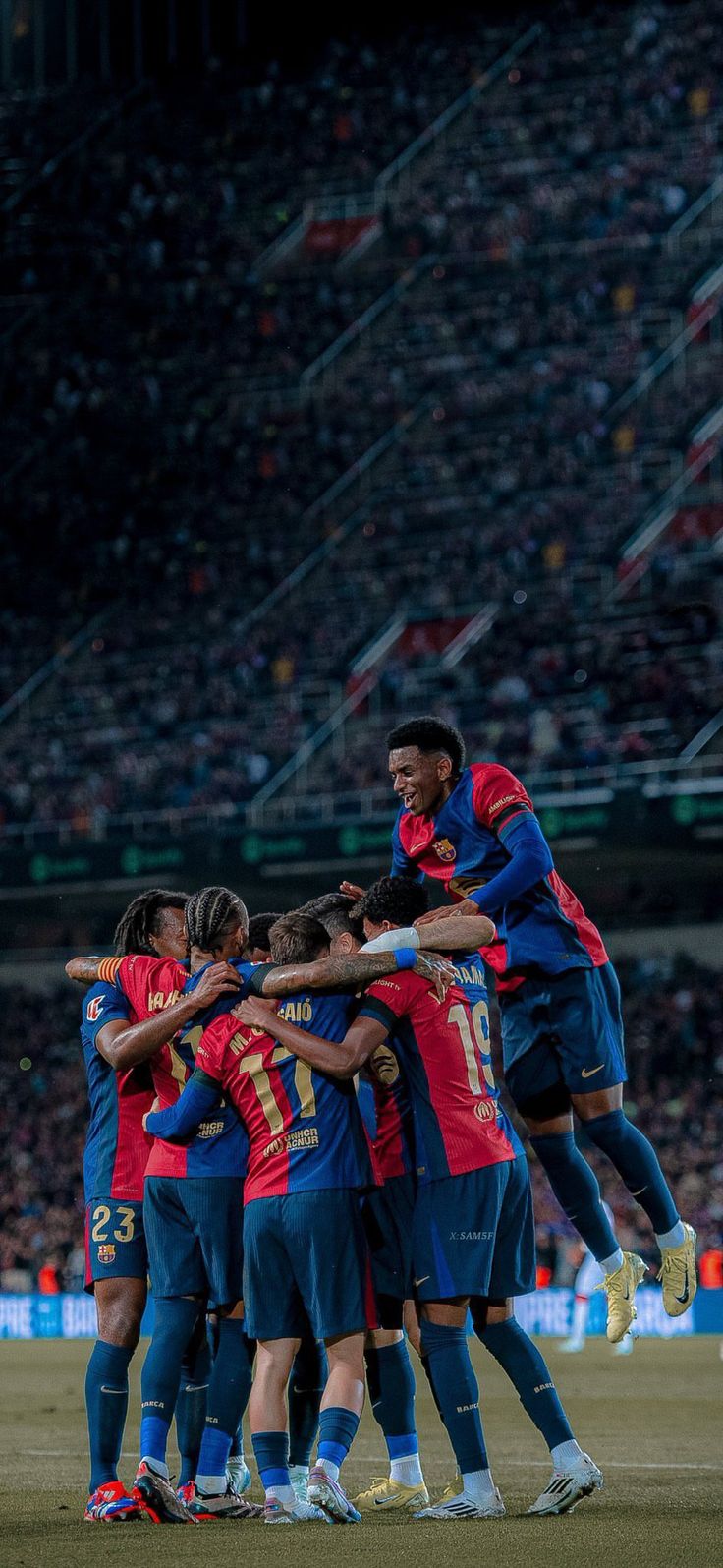 a group of soccer players huddle together on the field