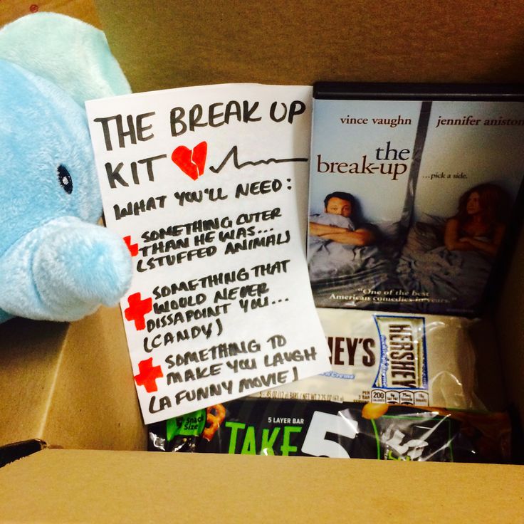 a blue stuffed animal sitting next to a box filled with books and other stuff items