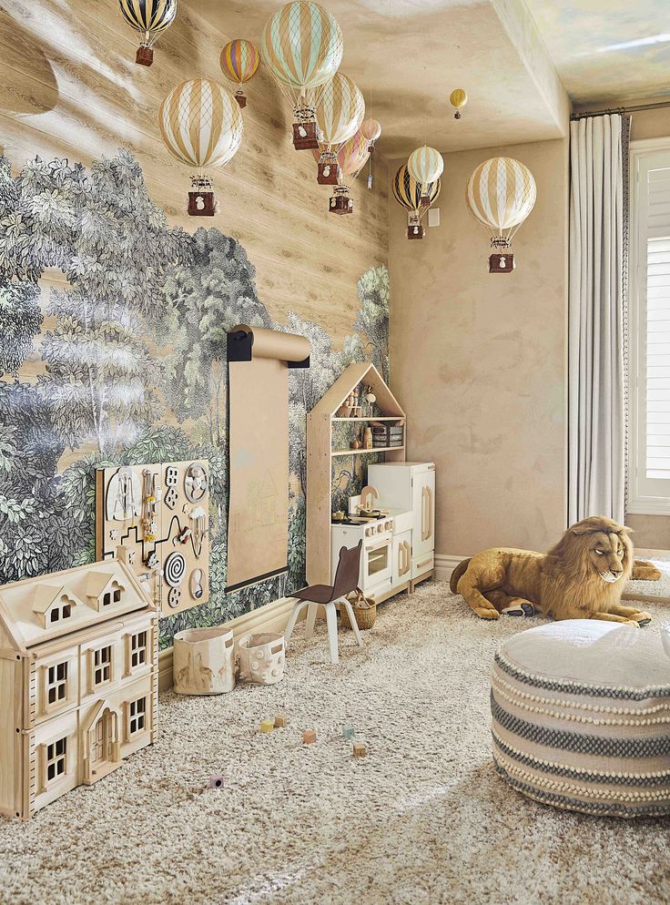 a child's room decorated in neutral tones and with hot air balloons hanging from the ceiling