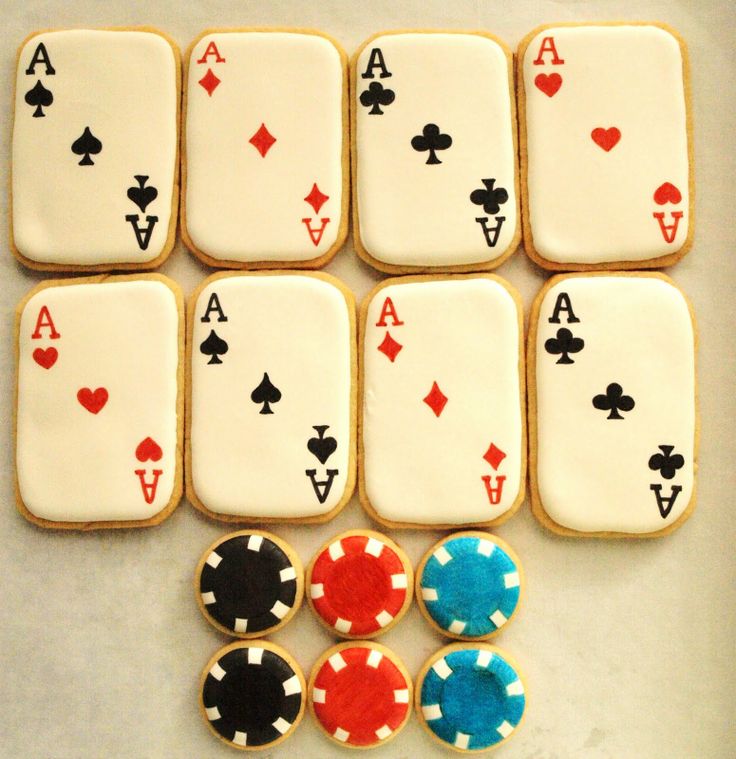 cookies decorated with playing cards and chips are sitting on a table next to each other