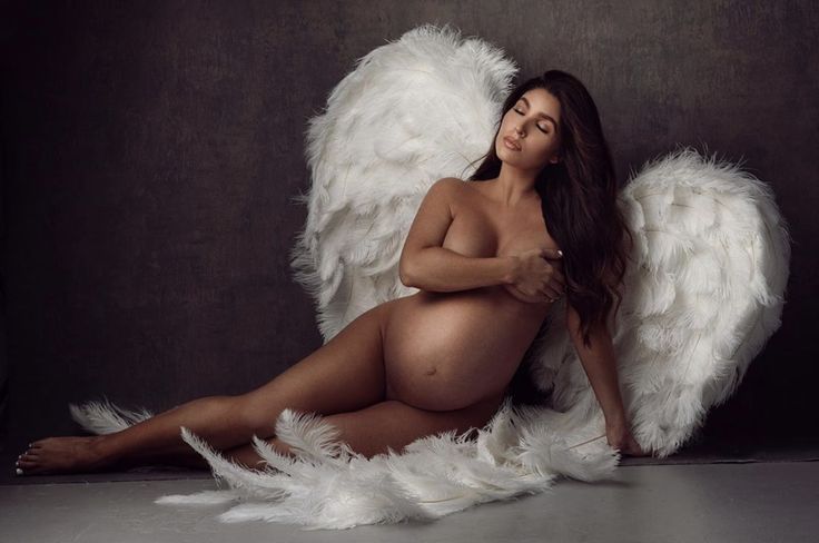 a naked woman with angel wings posing for the camera