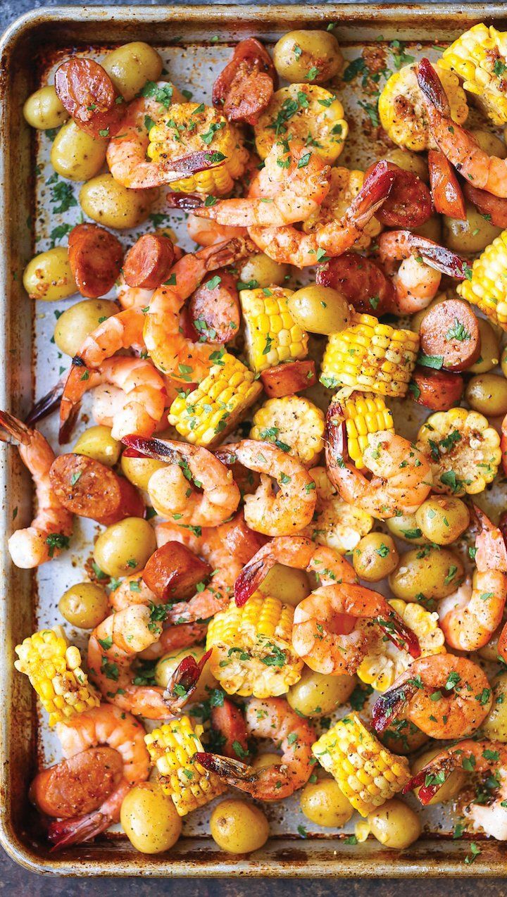 shrimp, corn and potatoes on a baking sheet