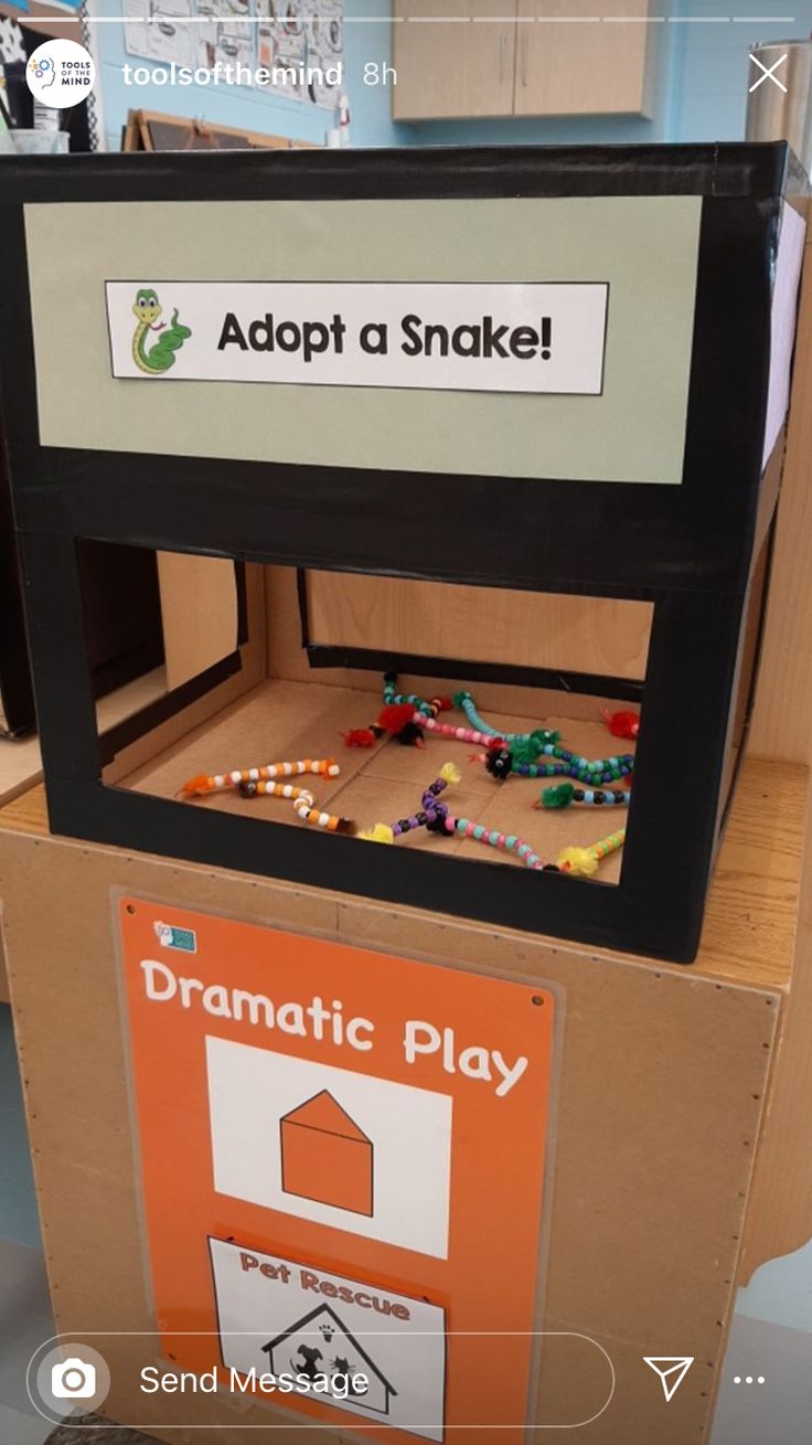 a cardboard box with a sign that says adopt a snake