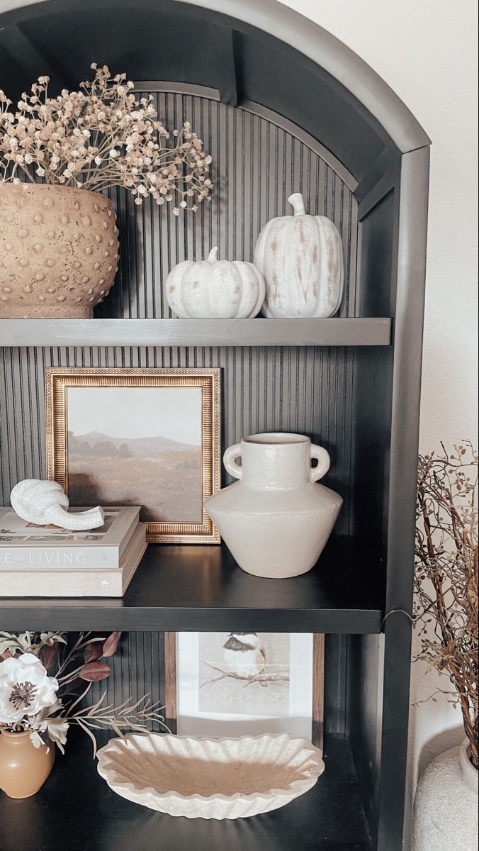 a shelf with vases and pictures on it