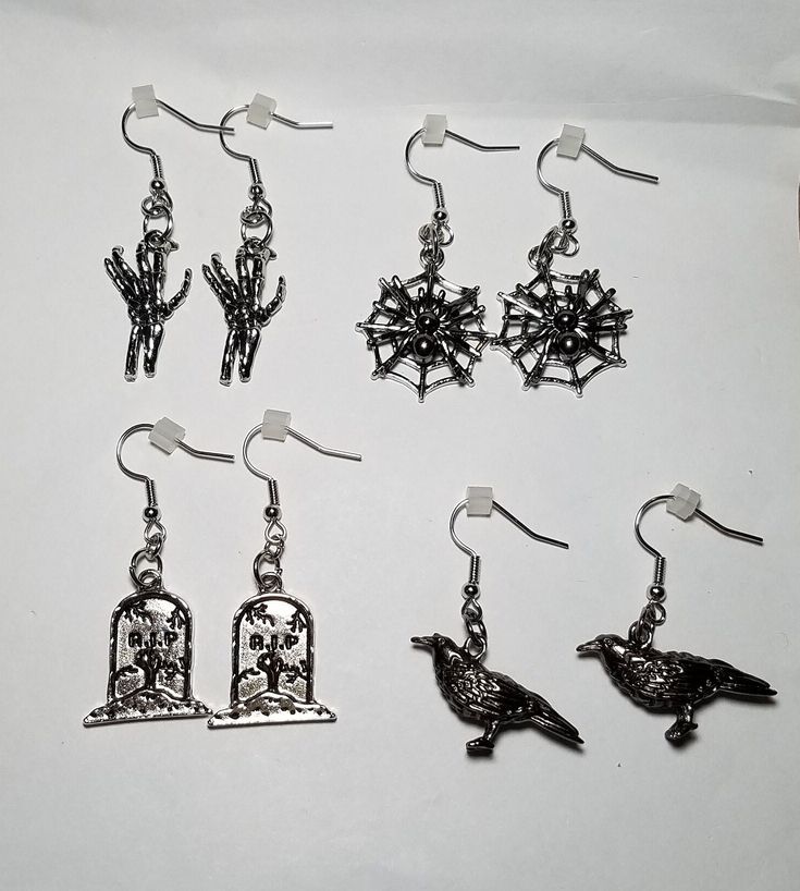 Halloween themed earrings made using different charms. Perfect for Halloween! Each earring measures approximately between 1.5 and 2 inches from top of earring wire to bottom of charms. Each pair comes with 2 earring backs as shown in picture. Themed Black Dangle Jewelry, Themed Black Dangle Earrings, Spooky Silver Dangle Earrings, Halloween Dangle Metal Earrings, Gothic Nickel-free Halloween Earrings, Halloween Themed Silver Earrings, Gothic Nickel-free Earrings For Halloween, Gothic Nickel Free Earrings For Halloween, Witchy Metal Earrings For Halloween