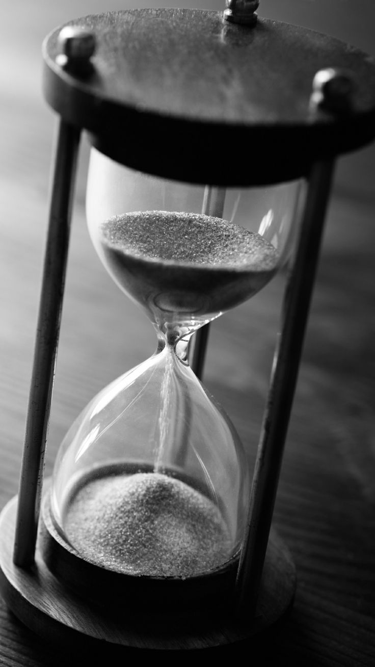 an hourglass sitting on top of a wooden table