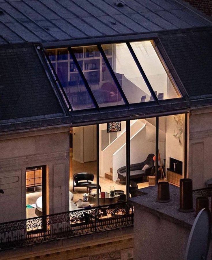 an apartment building is lit up at night with its windows open to let in light