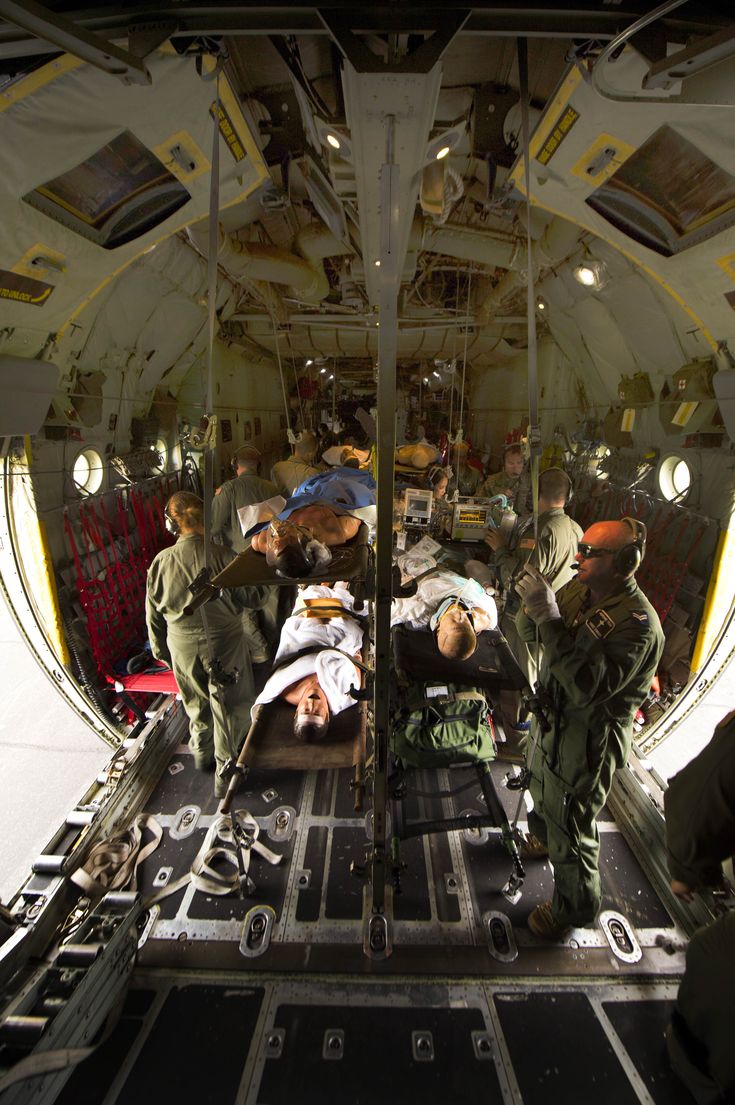 the inside of an airplane with several people in it and one person laying on the ground