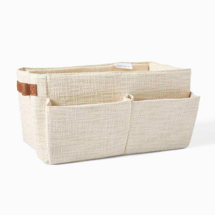 two canvas storage bins with leather handles, one in beige and the other in white