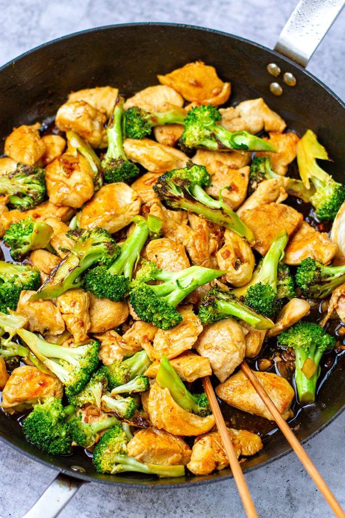 chicken and broccoli stir fry in a wok with chopsticks on the side