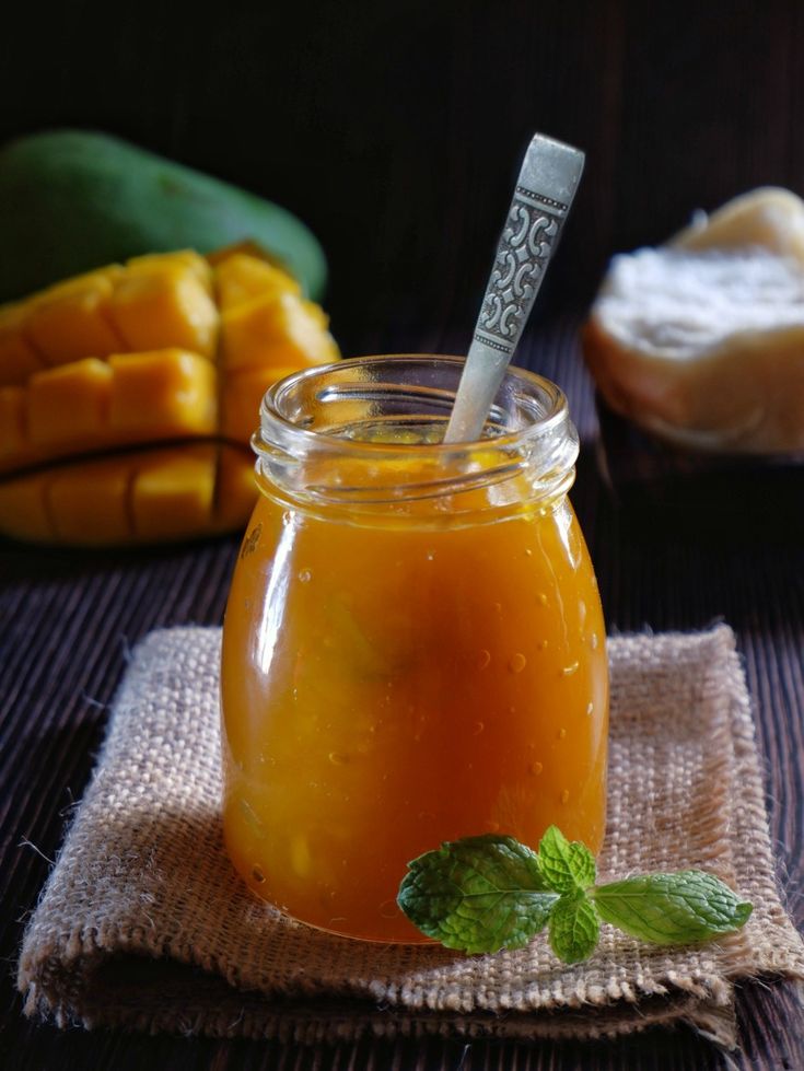 a glass jar filled with liquid sitting on top of a table next to other food